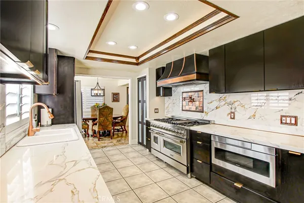 a kitchen with stainless steel appliances kitchen island granite countertop a stove and a sink