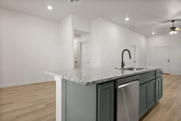 a kitchen with a sink and a wooden floor