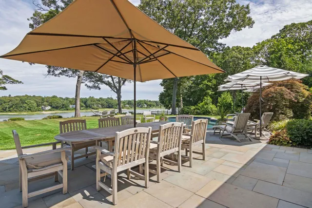 a view of a swimming pool with lawn chairs under an umbrella
