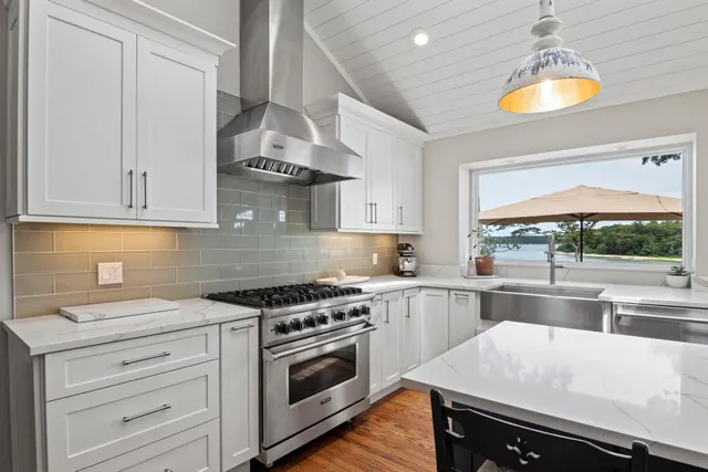 a kitchen with a stove a refrigerator and a dining table with wooden floor