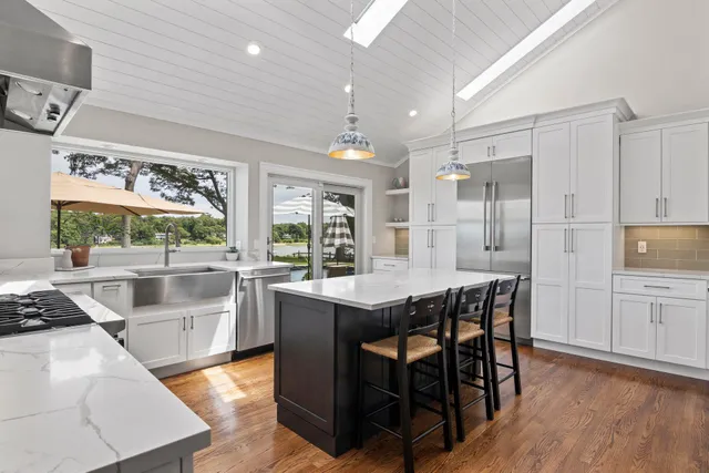 a kitchen with stainless steel appliances granite countertop wooden floor window and cabinets