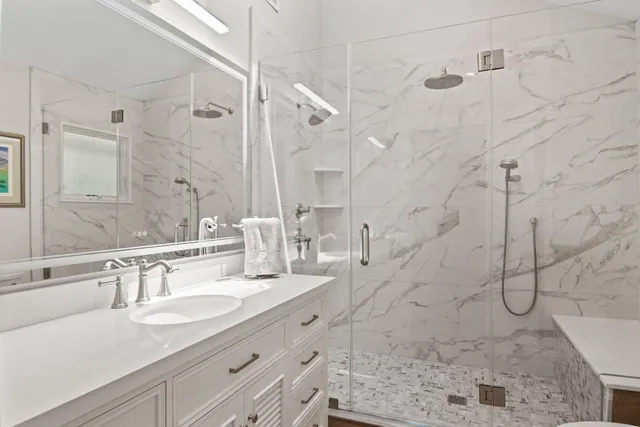 a bathroom with a granite countertop sink a shower and a mirror