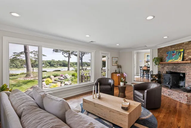a living room with fireplace furniture and a large window
