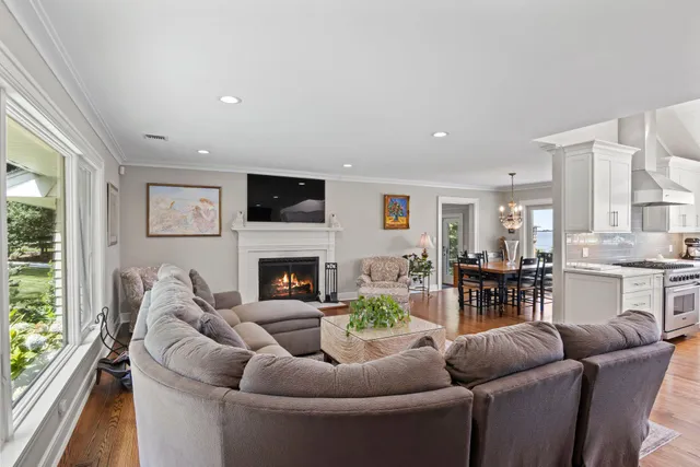 a living room with furniture fireplace and a large window