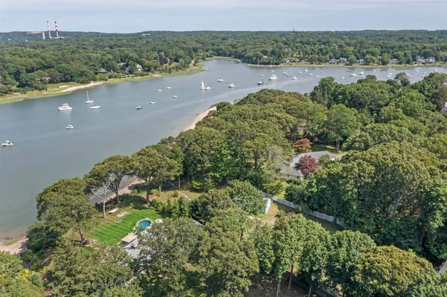 an aerial view of a house with a yard and lake view