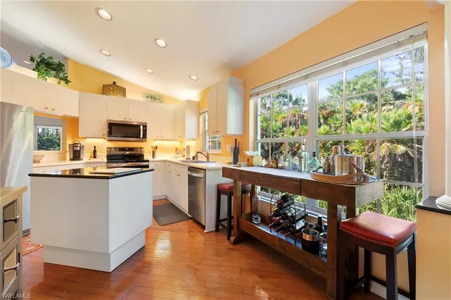 a kitchen with a table chairs sink and cabinets