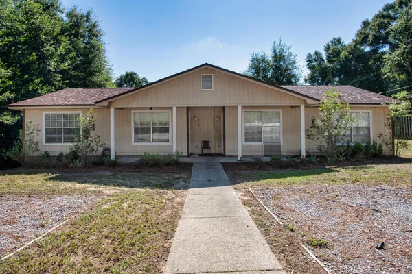 a front view of a house with a yard and trees