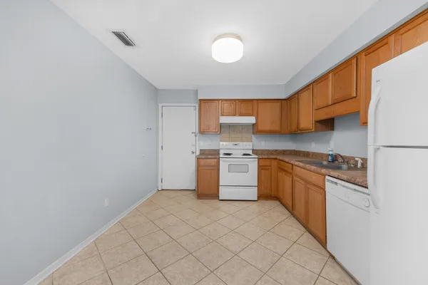 a kitchen with stainless steel appliances granite countertop a stove a sink and a refrigerator
