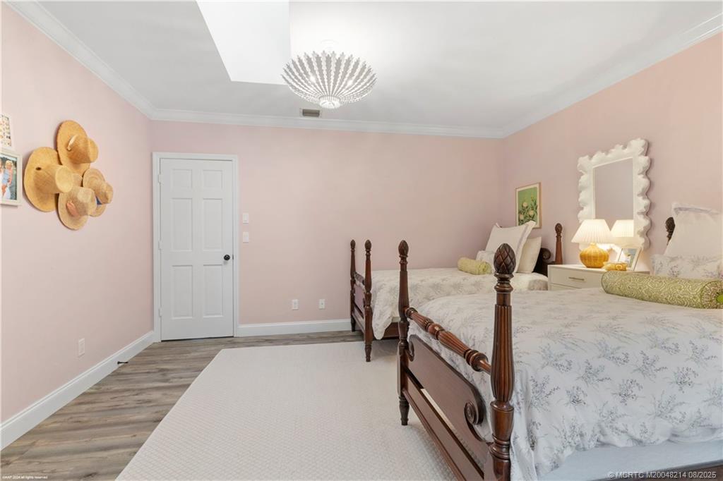 16 Ridgeview Road North Sewall's Point, FL 34996 - Photo 54 of 88 a bedroom with a bed and a chandelier