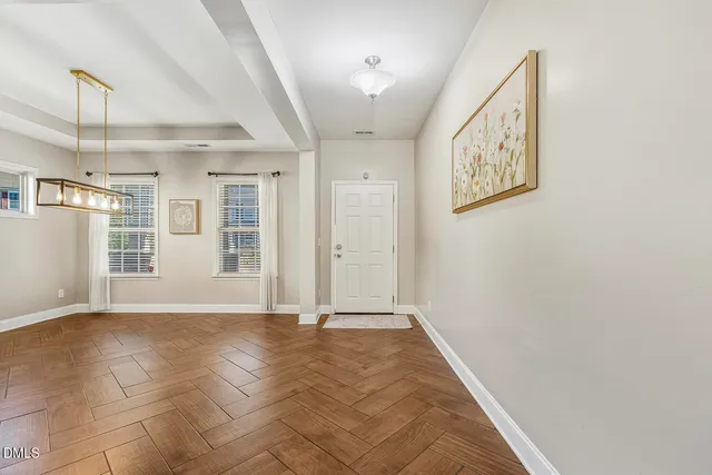 a view of an empty room with wooden floor