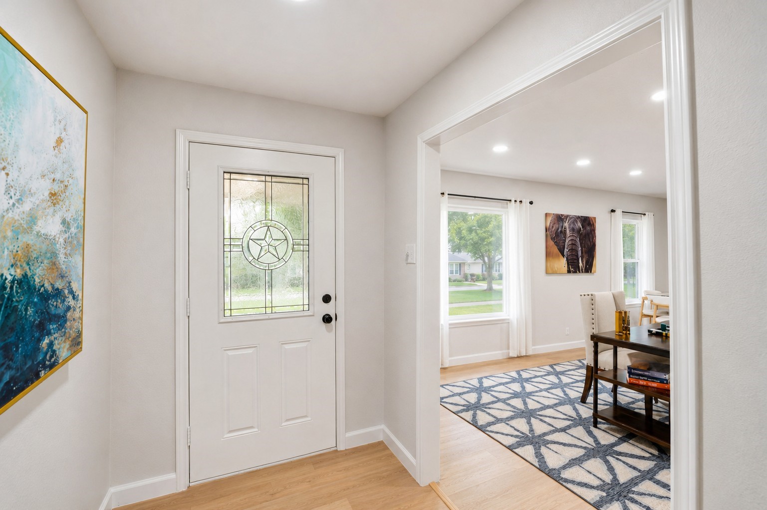 12703 Redfern Drive Houston, TX 77048 - Photo 5 of 28 Featuring modern light wood flooring, soft neutral tones, and charming decorative glass front door details, this inviting foyer offers the perfect blend of timeless character and fresh contemporary updates.
