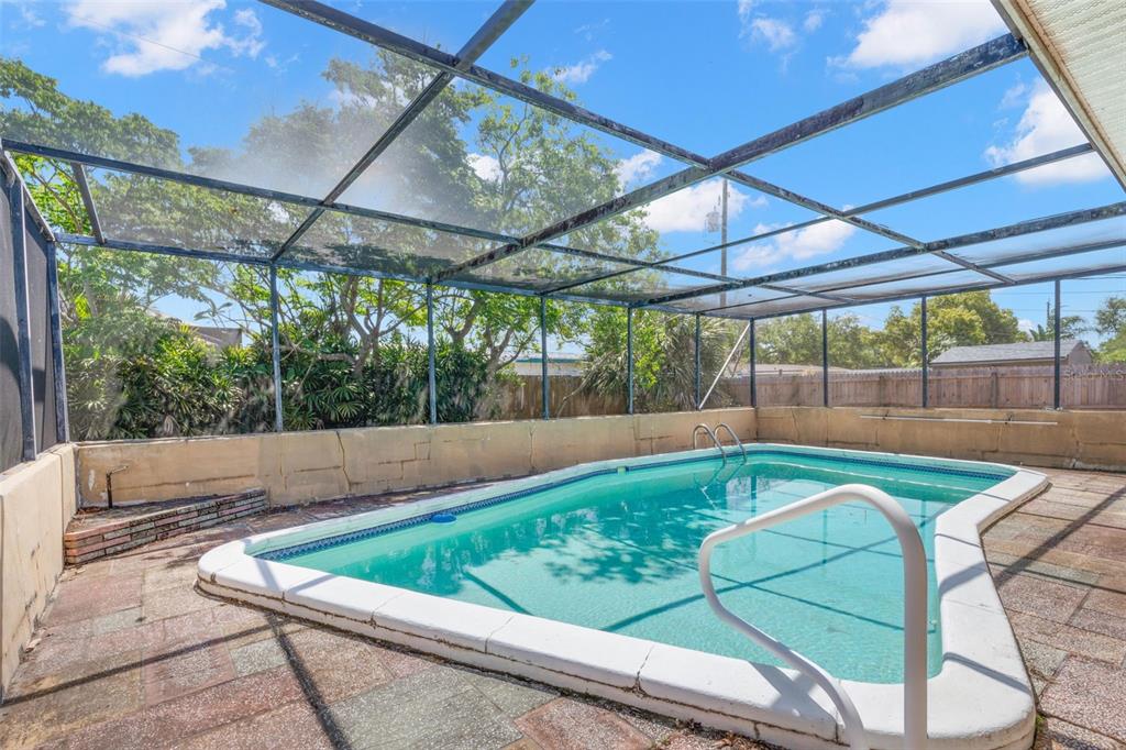909 Woodley Road Clearwater, FL 33764 - Photo 14 of 29 a view of a backyard with table and chairs under an umbrella