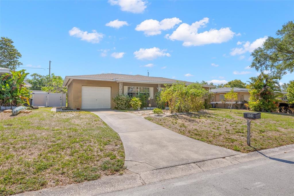 909 Woodley Road Clearwater, FL 33764 - Photo 2 of 29 a front view of a house with garden