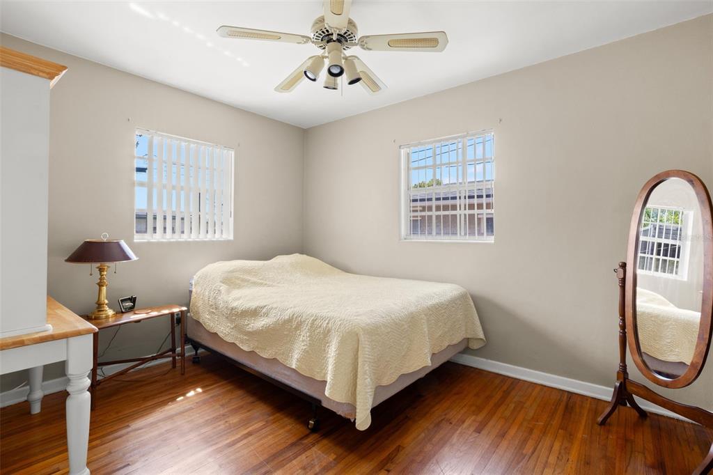 909 Woodley Road Clearwater, FL 33764 - Photo 23 of 29 a bedroom with a bed wooden floor and window