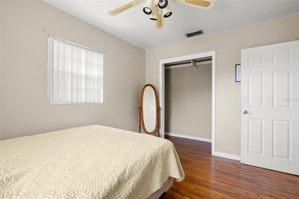 909 Woodley Road Clearwater, FL 33764 - Photo 24 of 29 a bedroom with a bed and a dresser with wooden floor