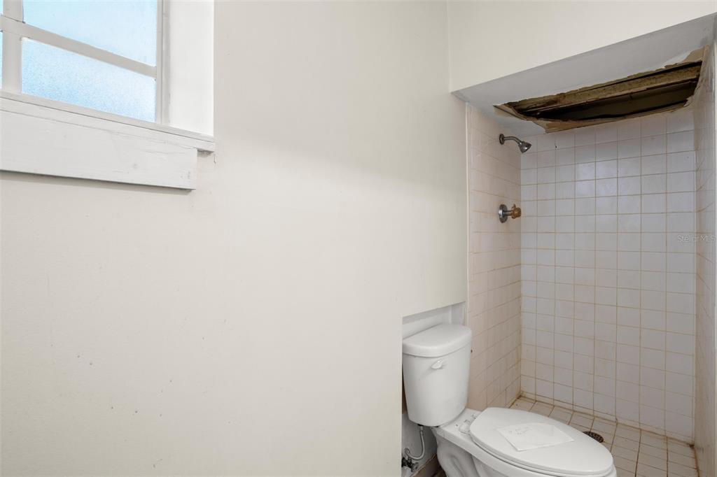 909 Woodley Road Clearwater, FL 33764 - Photo 27 of 29 a white toilet sitting next to a shower