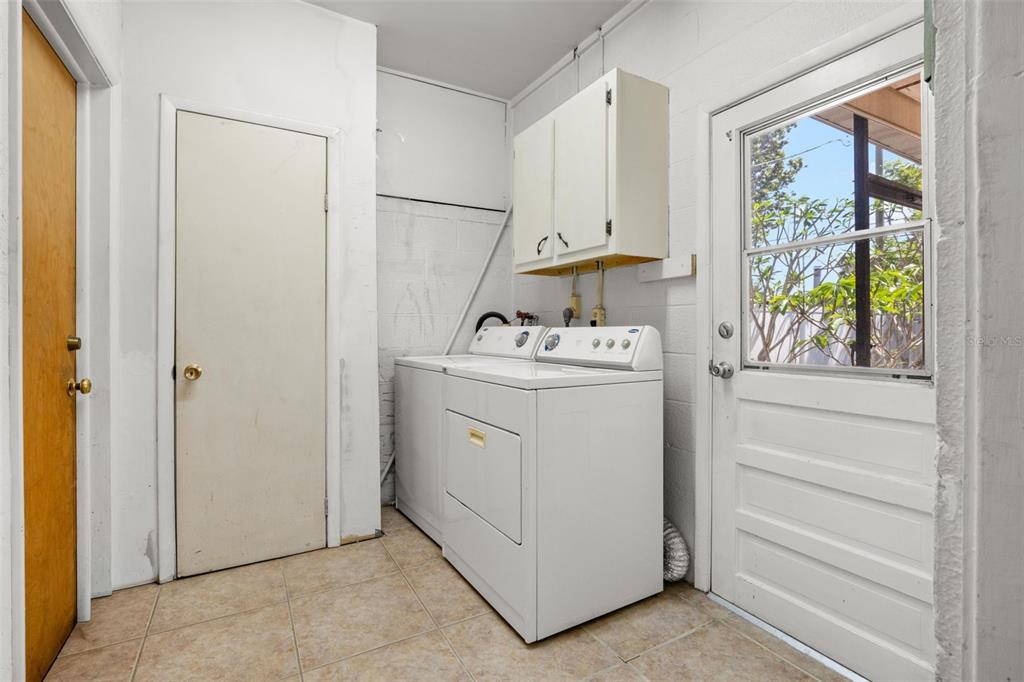 909 Woodley Road Clearwater, FL 33764 - Photo 28 of 29 a utility room with cabinets washer and dryer