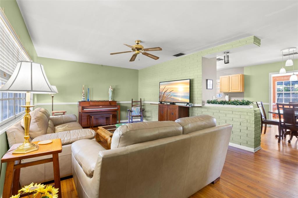 909 Woodley Road Clearwater, FL 33764 - Photo 4 of 29 a living room with furniture a dining table and a chandelier