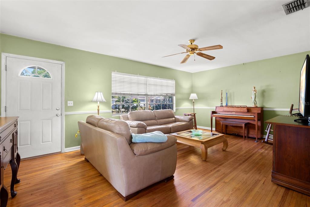 909 Woodley Road Clearwater, FL 33764 - Photo 5 of 29 a living room with furniture fireplace and wooden floor