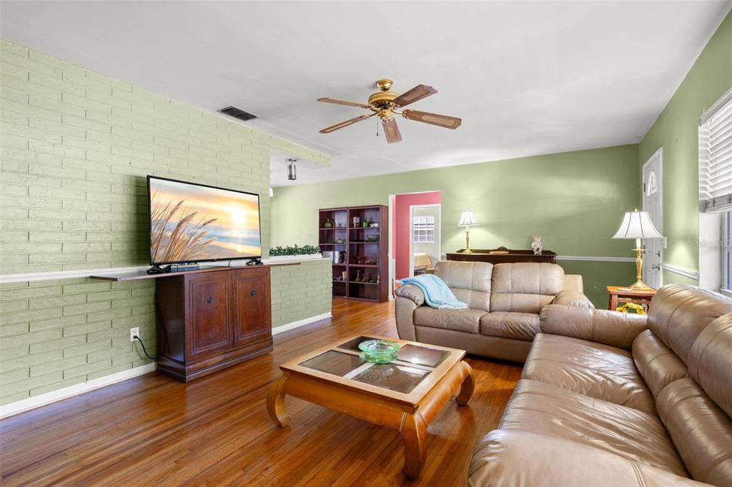 909 Woodley Road Clearwater, FL 33764 - Photo 7 of 29 a living room with furniture and a flat screen tv