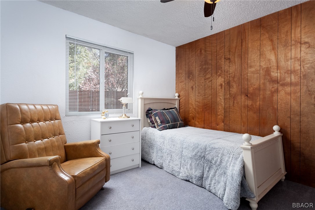 590 Riverside Avenue Sugarloaf, CA 92386 - Photo 17 of 20 a bedroom with a couch and a window