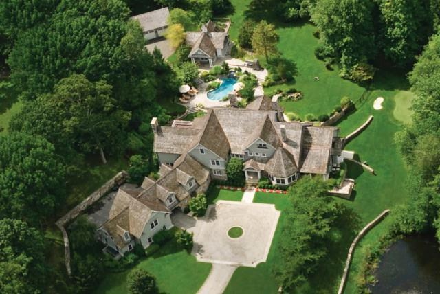 an aerial view of a house with a yard and lake view