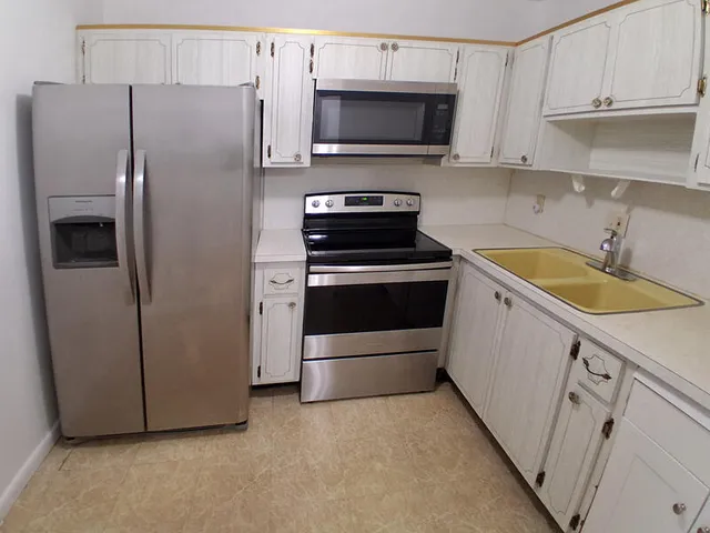 a kitchen with a refrigerator sink and microwave