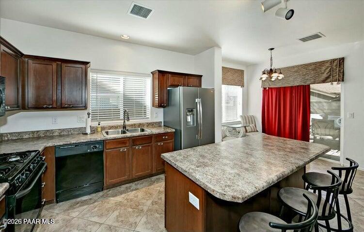 650 North Robles Street Dewey, AZ 86327 - Photo 6 of 13 a kitchen with stainless steel appliances granite countertop wooden cabinets a stove top oven a refrigerator and dishwasher