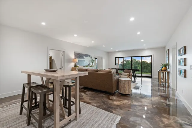 a living room with furniture pool table and window