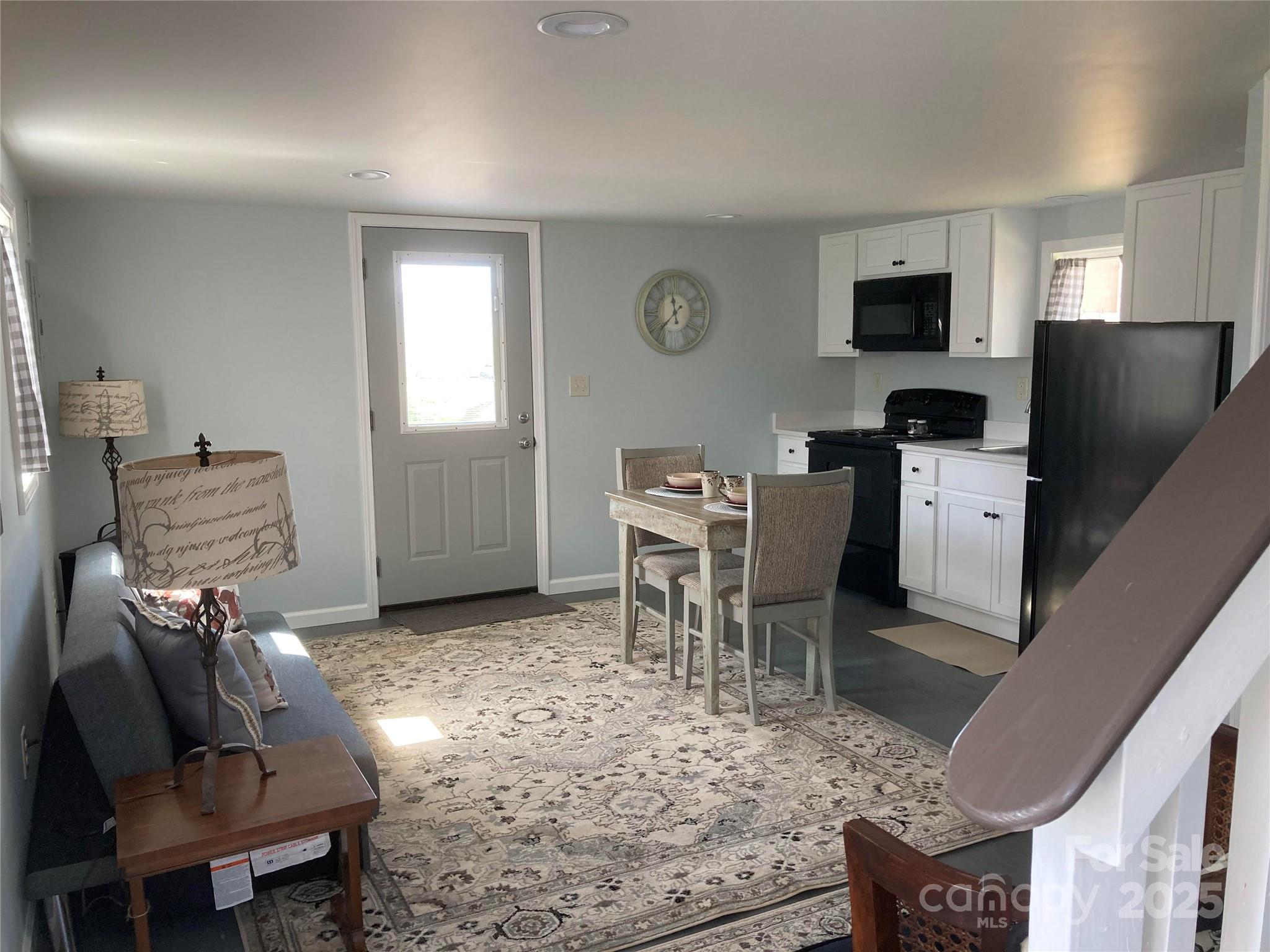 1434 Lake Adger Road Mill Spring, NC 28756 - Photo 28 of 48 a living room with furniture a flat screen tv and kitchen view