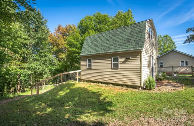 a view of a backyard with plants and a large tree
