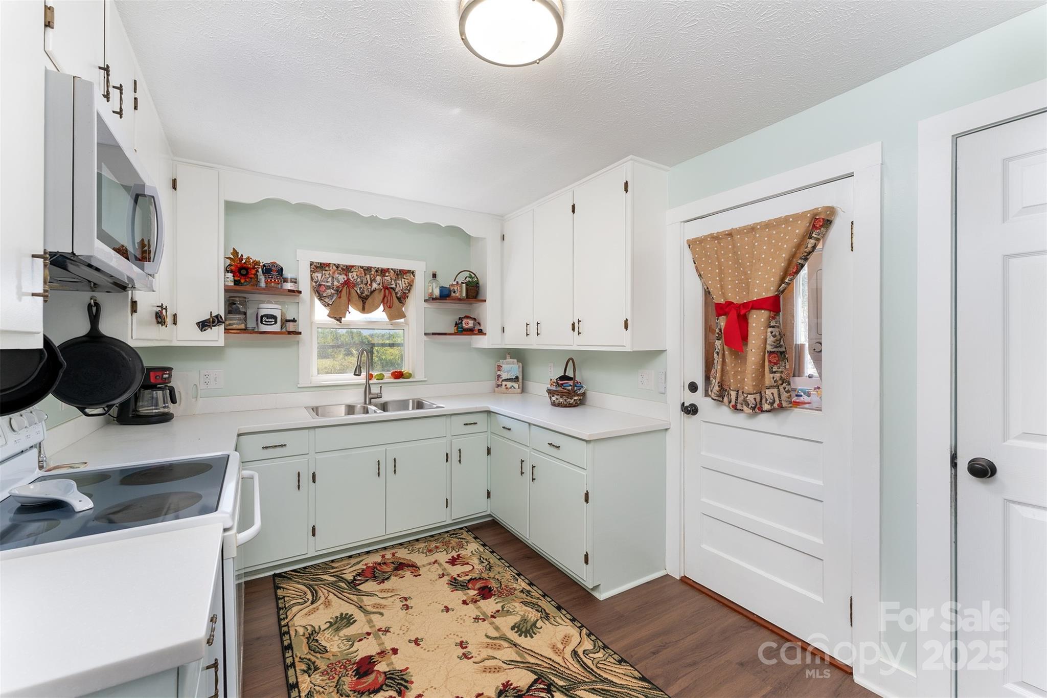 1434 Lake Adger Road Mill Spring, NC 28756 - Photo 10 of 48 a kitchen with white cabinets and sink