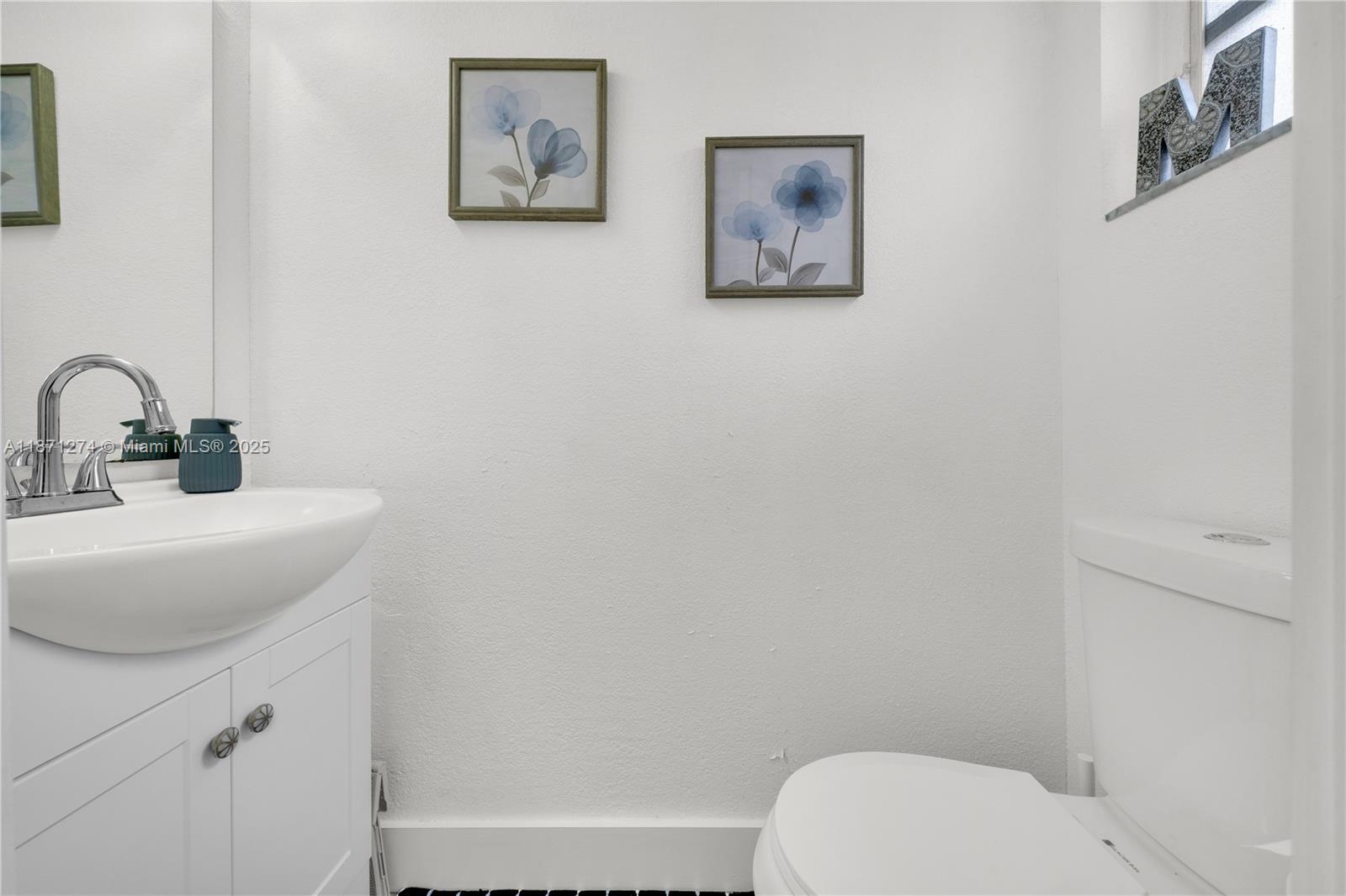 830 Northwest 87th Avenue, Unit 406 Miami, FL 33172 - Photo 16 of 40 a bathroom with a toilet a sink and a mirror