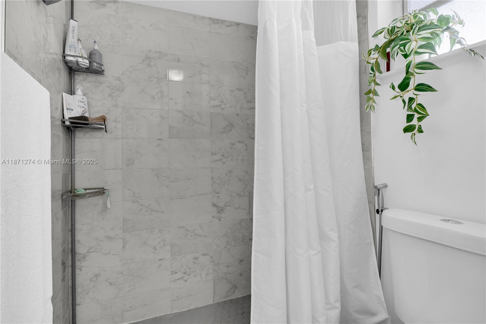 830 Northwest 87th Avenue, Unit 406 Miami, FL 33172 - Photo 30 of 40 a bathroom with a shower curtain