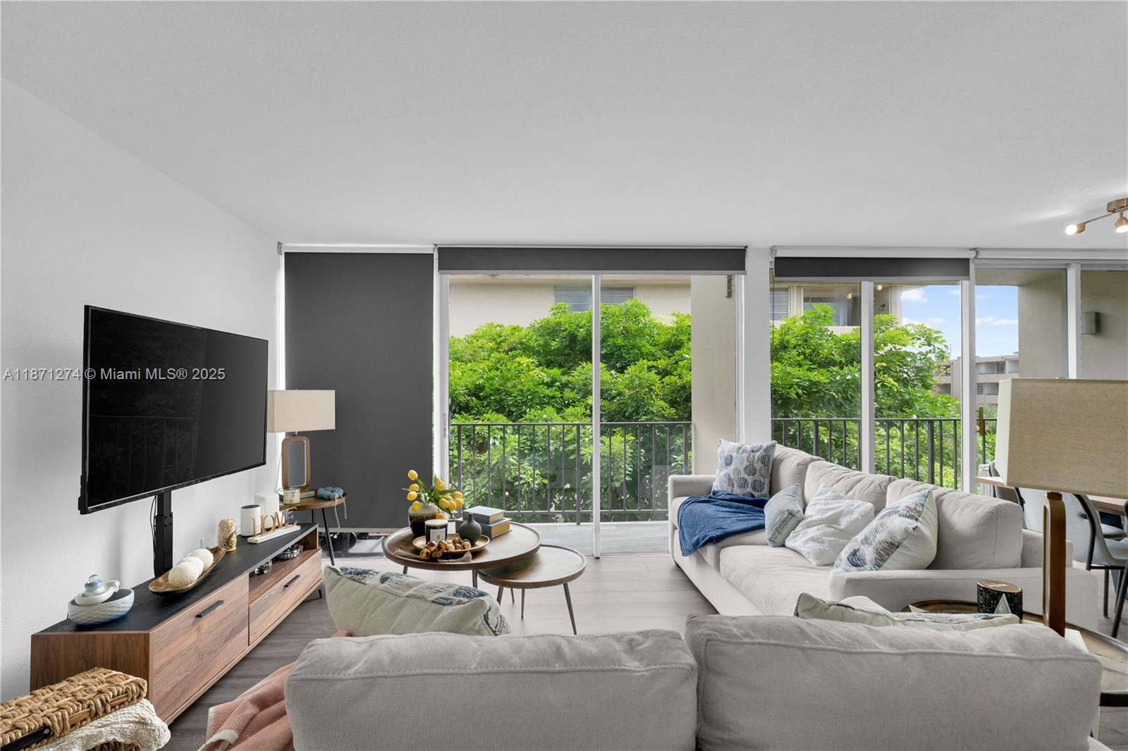 830 Northwest 87th Avenue, Unit 406 Miami, FL 33172 - Photo 9 of 40 a living room with furniture a large window and a flat screen tv