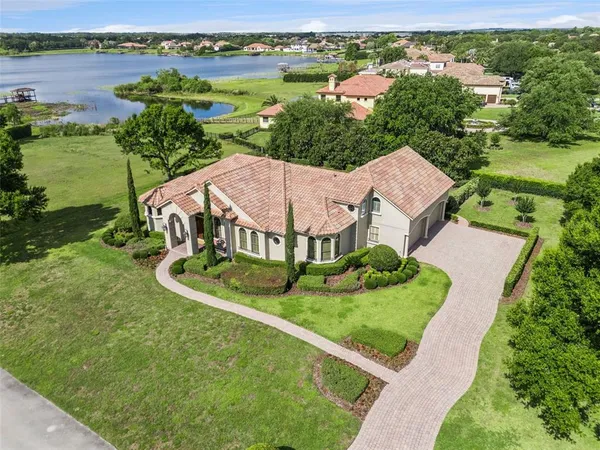 an aerial view of a house with outdoor space and lake view