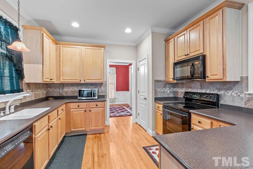 5725 Turner Store Lane Raleigh, NC 27603 - Photo 14 of 30 a kitchen with stainless steel appliances granite countertop a stove top oven a sink dishwasher and a microwave oven with wooden floor