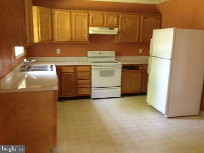 419 Burns Street Ranson, WV 25438 - Photo 19 of 22 a kitchen with a refrigerator sink stove and cabinets