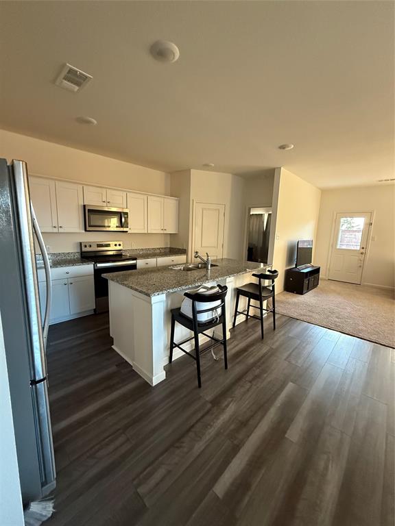1852 McCree Street Forney, TX 75126 - Photo 13 of 21 a kitchen with stainless steel appliances a stove a sink dishwasher a refrigerator with white cabinets and wooden floor