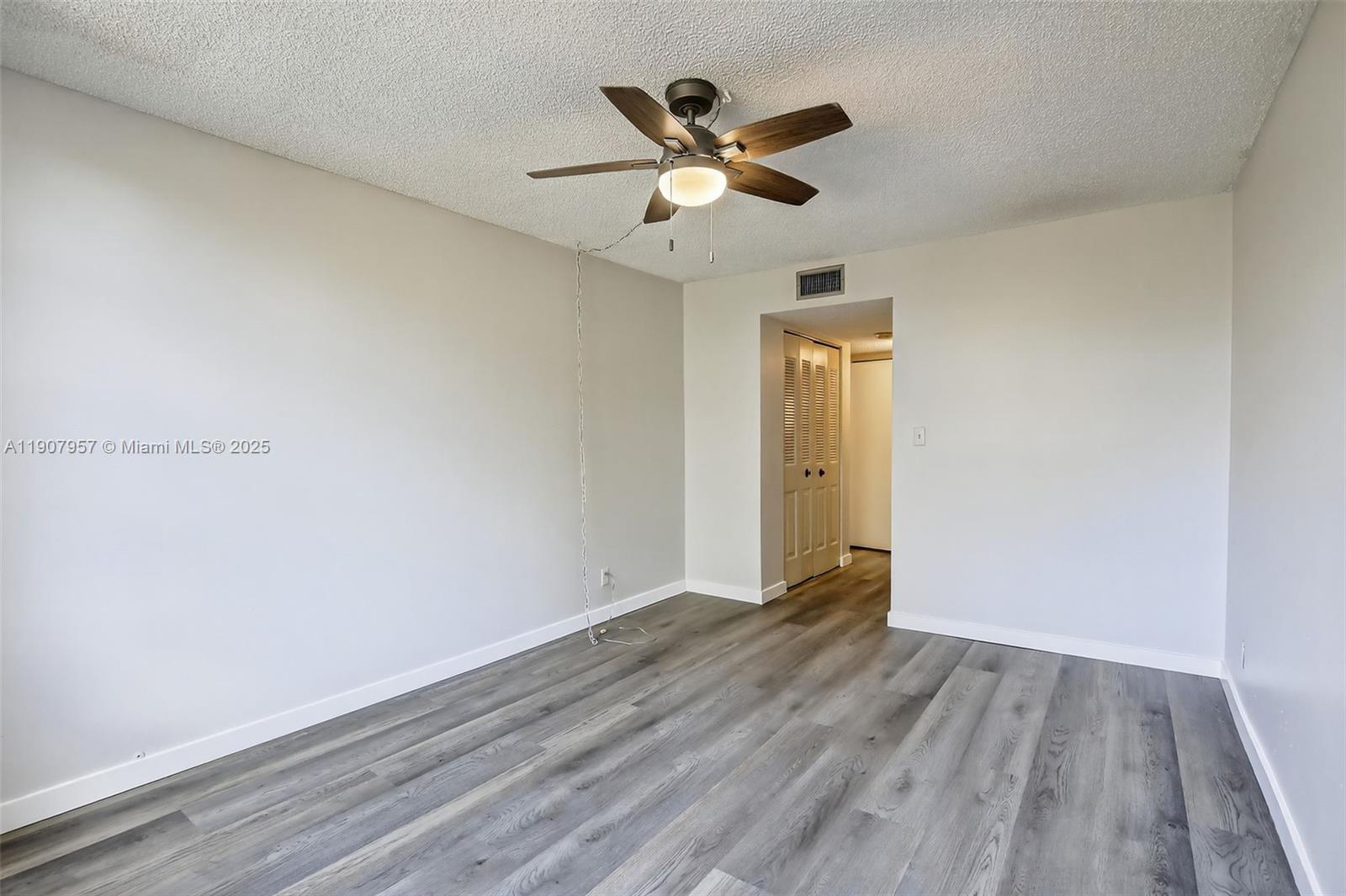 6500 Cypress Road, Unit 410 Plantation, FL 33317 - Photo 15 of 33 an empty room with wooden floor and a ceiling fan