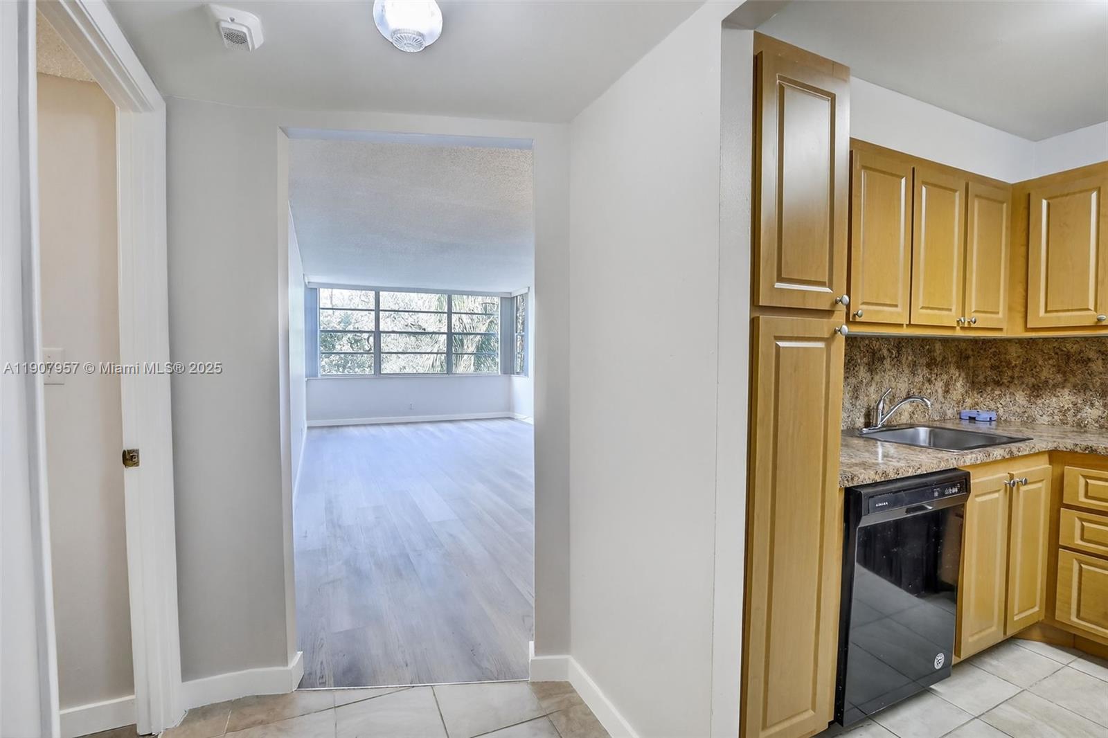 6500 Cypress Road, Unit 410 Plantation, FL 33317 - Photo 2 of 33 a view of a kitchen from the hallway with windows