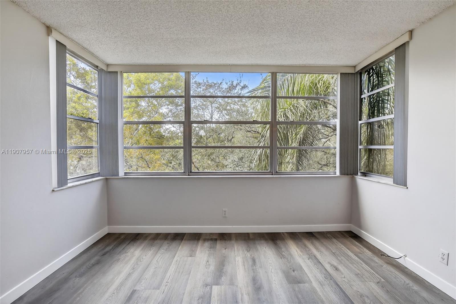 6500 Cypress Road, Unit 410 Plantation, FL 33317 - Photo 9 of 33 a view of an empty room with wooden floor and a window