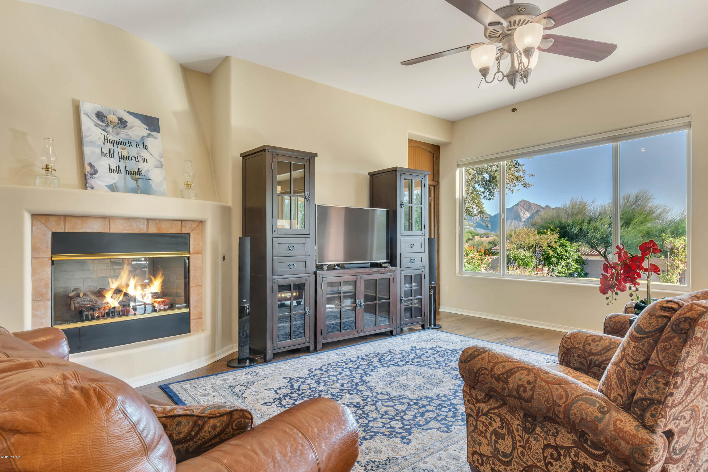 12682 North Spirit Mountain Road Oro Valley, AZ 85755 - Photo 4 of 40 a living room with furniture a fireplace and a large window