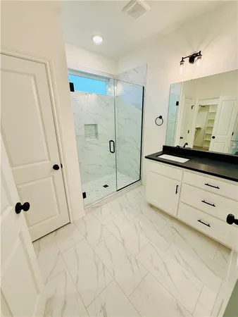 a bathroom with a double vanity sink a mirror a shower and a bathtub
