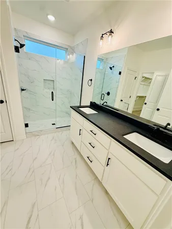 a bathroom with a double vanity sink mirror and shower