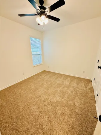 an empty room with a ceiling fan and a window