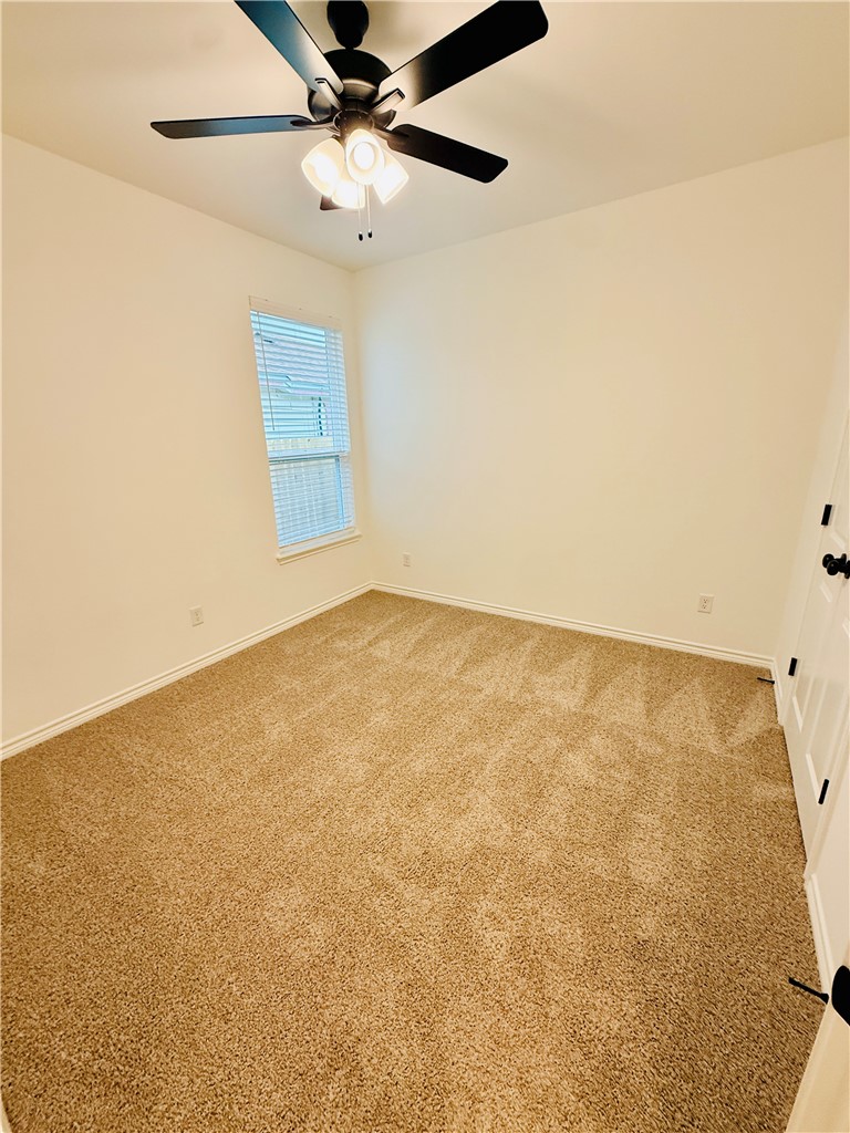 1202 Suncrest Street Bryan, TX 77803 - Photo 15 of 21 an empty room with a ceiling fan and a window