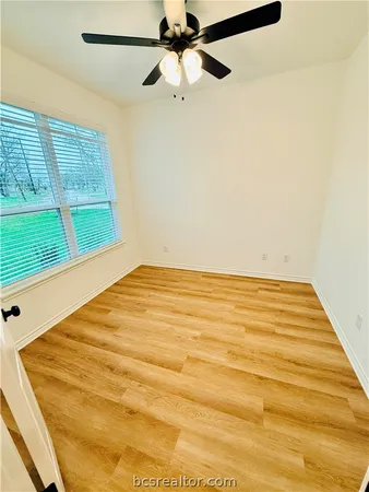 a view of a room with a ceiling fan and a window