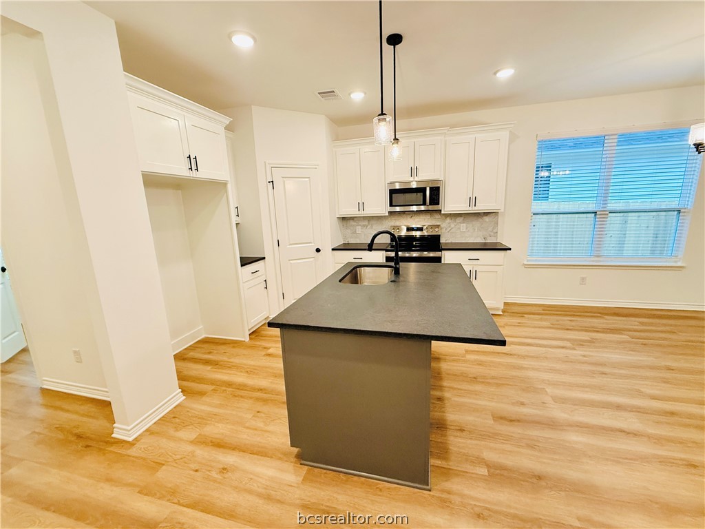 1202 Suncrest Street Bryan, TX 77803 - Photo 4 of 21 a kitchen with stainless steel appliances granite countertop a sink a stove and a refrigerator