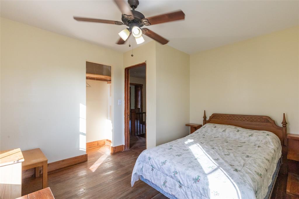 640 Ground Street Moran, TX 76464 - Photo 29 of 35 Bedroom featuring wood-finish flooring, a ceiling fan with integrated lighting, and a closet with a wood trim opening